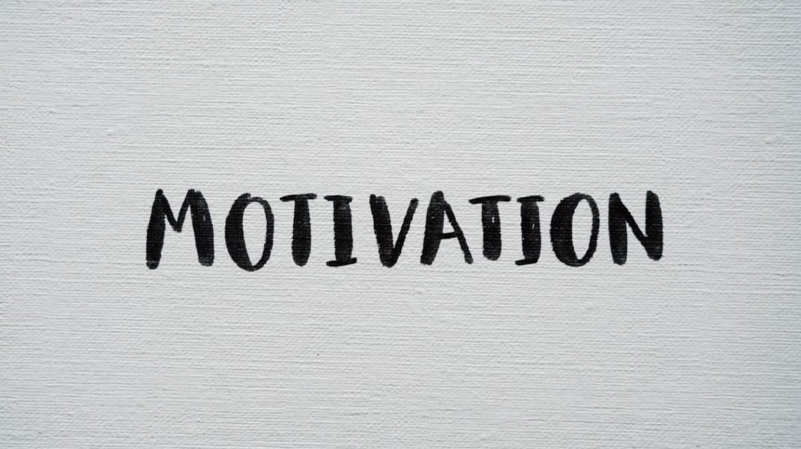 Inspirational word 'Motivation' in black on a white textured canvas background.